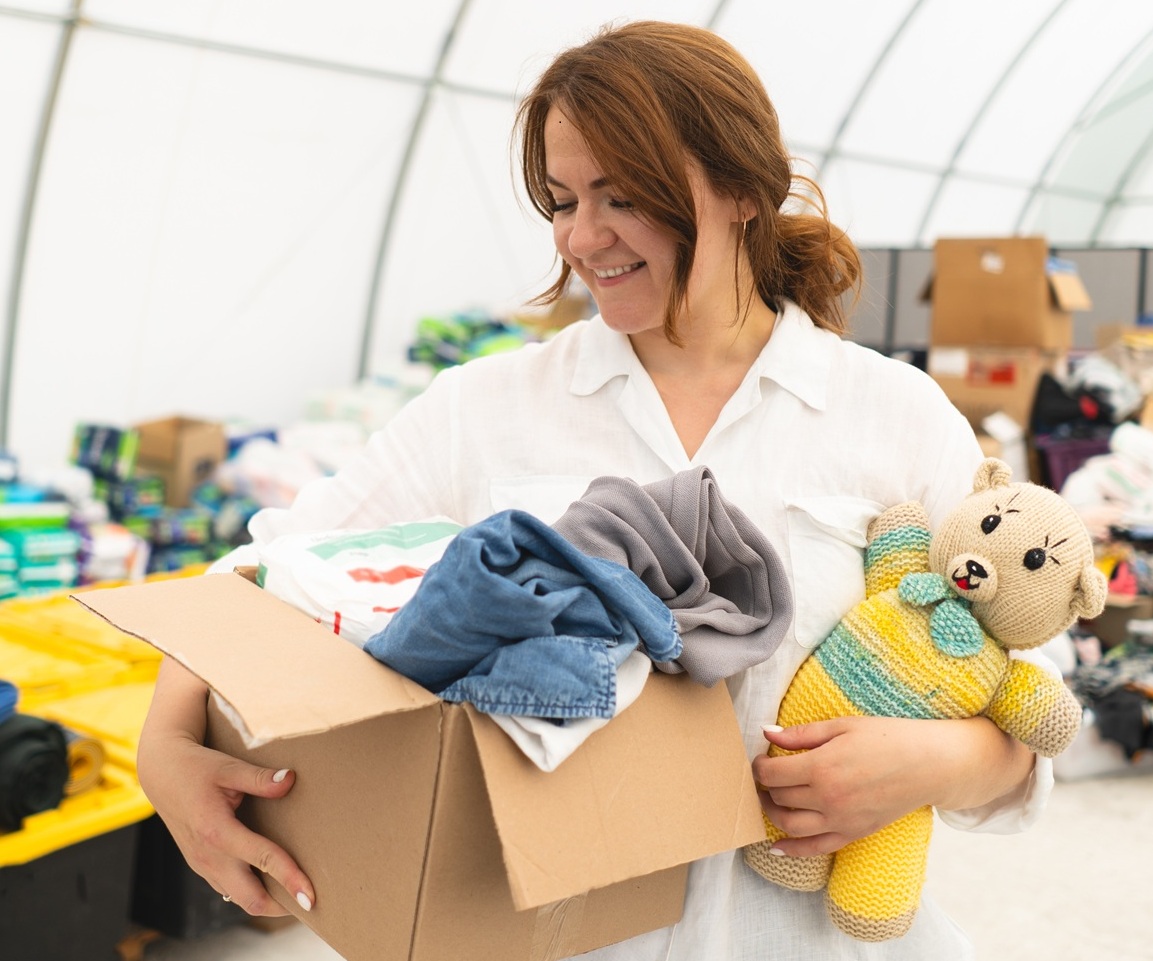 Volunteer woman preparing donation boxes for people.